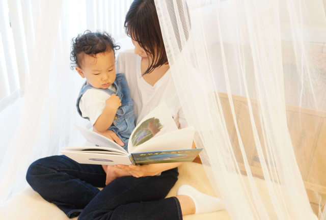 就寝前に絵本を読み聞かせる親子のあたたかな時間